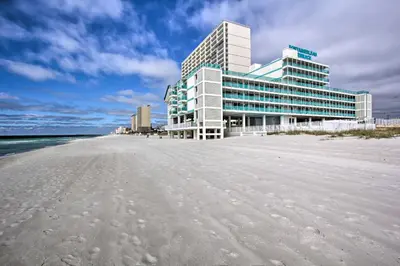 a building on the beach next to the ocean at Panama City Beach Studio with Pool and Beach Access in Panama City Beach
