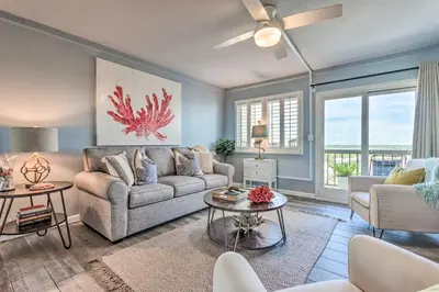 a living room with a couch and a table at PCB Beachfront Coastal Abode at Pinnacle Port! in Panama City Beach
