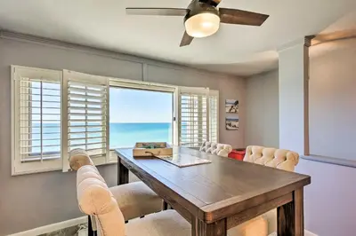 a dining room with a table and chairs and a window at PCB Beachfront Coastal Abode at Pinnacle Port! in Panama City Beach