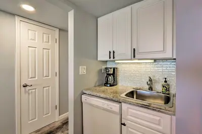 a kitchen with white cabinets and a sink at PCB Beachfront Coastal Abode at Pinnacle Port! in Panama City Beach