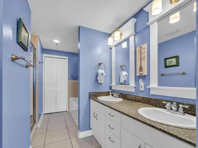 a bathroom with two sinks and blue walls at Grand Panama 2-705 in Panama City Beach