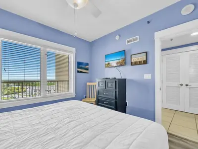 a blue bedroom with a bed and a television at Grand Panama 2-705 in Panama City Beach