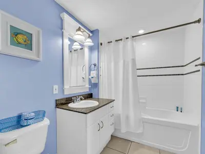 a bathroom with a sink and a tub and a toilet at Grand Panama 2-705 in Panama City Beach