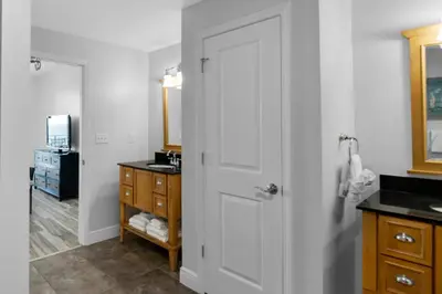 a bathroom with a white door and a sink at Sterling Breeze 2006 in Panama City Beach