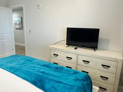a bedroom with a bed and a television on a dresser at Sterling Breeze 2006 in Panama City Beach