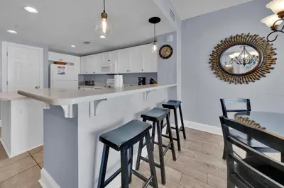a kitchen with a bar with stools and a counter at Majestic Beach Towers 2-1206 in Panama City Beach