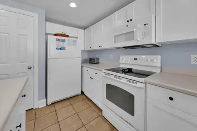 a kitchen with white appliances and white cabinets at Majestic Beach Towers 2-1206 in Panama City Beach
