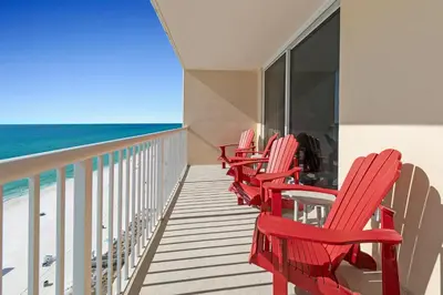 a row of red chairs on a balcony overlooking the ocean at Majestic Beach Towers 2-1206 in Panama City Beach