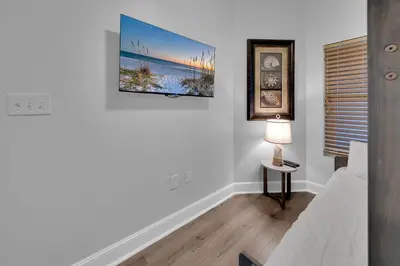 a living room with a couch and a tv on the wall at Majestic Beach Towers 2-1206 in Panama City Beach