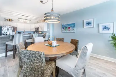 a dining room and kitchen with a wooden table and chairs at Ocean Villa 1406 in Panama City Beach