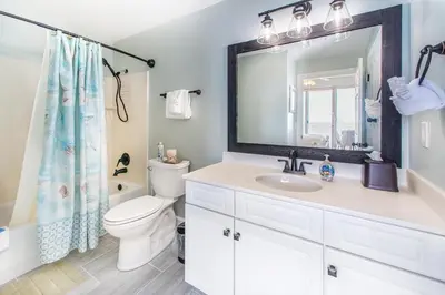 a bathroom with a toilet and a sink and a mirror at Ocean Villa 1406 in Panama City Beach