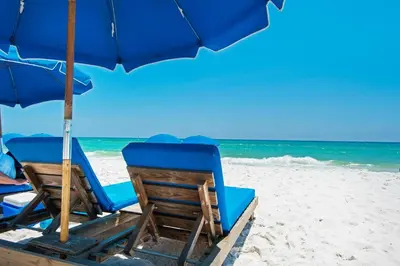 two chairs and an umbrella on a beach at Tidewater 2115 in Panama City Beach