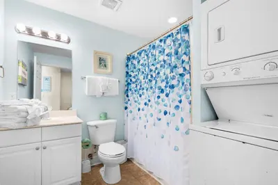 a white bathroom with a toilet and a shower at Tidewater 2115 in Panama City Beach