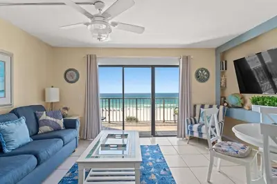 a living room with a blue couch and a view of the ocean at The Summit 506 in Panama City Beach