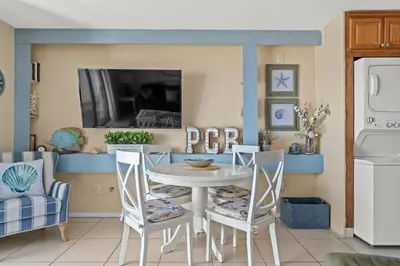 a dining room with a white table and chairs at The Summit 506 in Panama City Beach