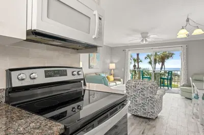 a kitchen with a stove top oven next to a living room at The Summit 228 in Panama City Beach