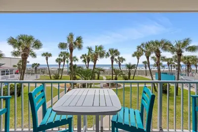 a table and chairs on a balcony with a view of the beach at The Summit 228 in Panama City Beach