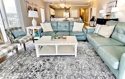 a living room with blue couches and a coffee table at Happy Ours 2200 sq ft corner beachfront sleeps 12 in Panama City Beach