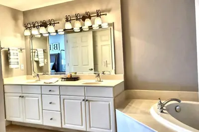 a bathroom with two sinks and a large mirror at Happy Ours 2200 sq ft corner beachfront sleeps 12 in Panama City Beach