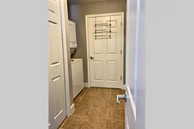 a hallway with a white door and a tile floor at Happy Ours 2200 sq ft corner beachfront sleeps 12 in Panama City Beach