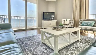 a living room with a couch and a tv at Happy Ours 2200 sq ft corner beachfront sleeps 12 in Panama City Beach
