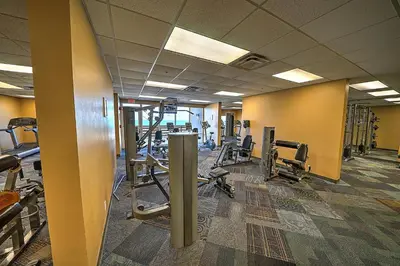 a gym with several rows of equipment in a room at Amazing Sunset Oceanfront Condo in Panama City Beach