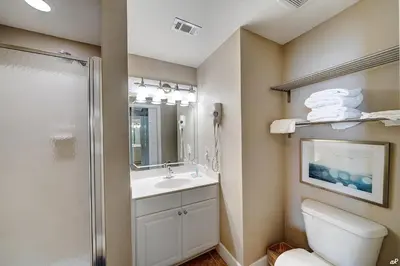 a bathroom with a toilet and a sink and a shower at Amazing Sunset Oceanfront Condo in Panama City Beach