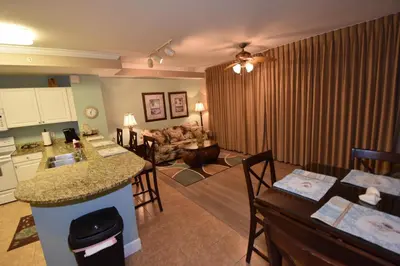 a living room with a kitchen and a living room with a couch at Amazing Sunset Oceanfront Condo in Panama City Beach