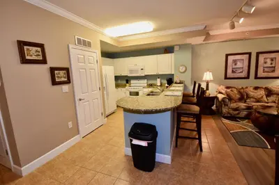 a kitchen and living room with a counter in a room at Amazing Sunset Oceanfront Condo in Panama City Beach