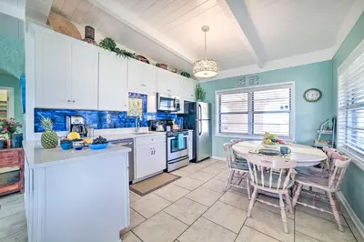 a kitchen with white cabinets and a table and chairs at Walk to Beach PCB Retreat with Private Pool! in Panama City Beach