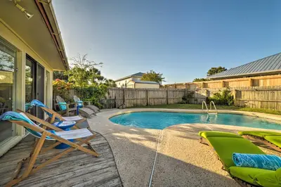 a backyard with a pool and chairs and a house at Walk to Beach PCB Retreat with Private Pool! in Panama City Beach