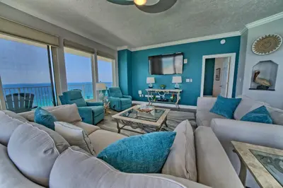 a living room with a large couch and blue walls at Calming Beachfront Condo with Oversized Balcony Facing the Gulf - Unit 2101 in Panama City Beach