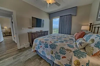a bedroom with a bed and a large window at Calming Beachfront Condo with Oversized Balcony Facing the Gulf - Unit 2101 in Panama City Beach