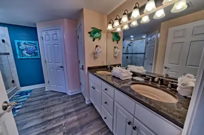 a bathroom with two sinks and a large mirror at Calming Beachfront Condo with Oversized Balcony Facing the Gulf - Unit 2101 in Panama City Beach