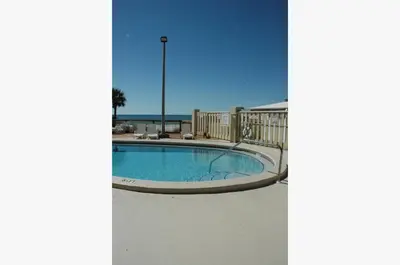 a swimming pool with the ocean in the background at Sunbird 0208W 'Surfside Sandcastle' in Panama City Beach