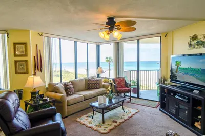 a living room with a couch and a flat screen tv at Sunbird 0208E 'Dolphin Watch' in Panama City Beach