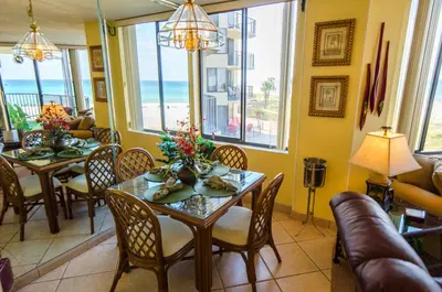 a dining room with a table and chairs and the ocean at Sunbird 0208E 'Dolphin Watch' in Panama City Beach