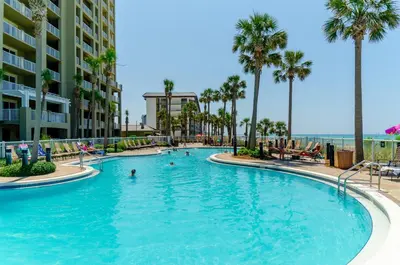 a swimming pool at a resort with palm trees at Grand Panama 1-1706 'Paradise Harbor' in Panama City Beach