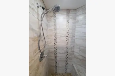a shower in a bathroom with marble tiles at Grand Panama 1-1706 'Paradise Harbor' in Panama City Beach