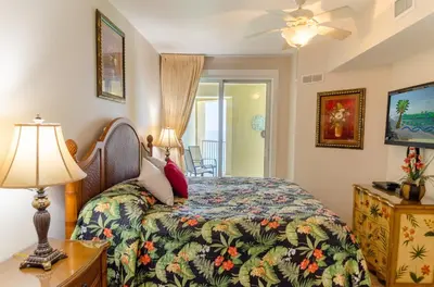 a bedroom with a bed and a table with a lamp at Grand Panama 1-1706 'Paradise Harbor' in Panama City Beach