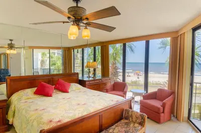 a bedroom with a bed and a view of the beach at Edgewater 2-0104 'Sandcastle Dreams' in Panama City Beach