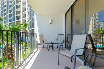 a balcony with chairs and tables on a building at Edgewater 2-0104 'Sandcastle Dreams' in Panama City Beach