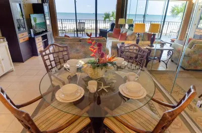 a dining room with a glass table and chairs at Edgewater 2-0104 'Sandcastle Dreams' in Panama City Beach