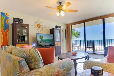 a living room with a couch and a tv at Edgewater 2-0104 'Sandcastle Dreams' in Panama City Beach