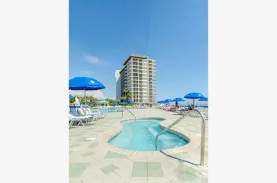 a pool with umbrellas and chairs and a building at Edgewater 2-0811 'Beach Lovers Paradise' in Panama City Beach