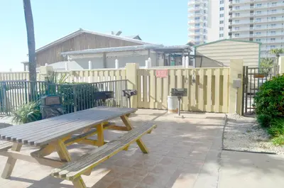 a wooden bench sitting on a sidewalk next to a fence at Sunbird 0908W 'Captain's Cove' in Panama City Beach