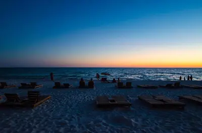 a group of people on a beach at sunset at Sunbird 0908W 'Captain's Cove' in Panama City Beach