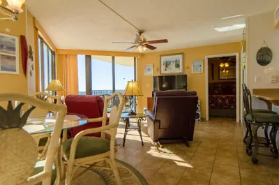 a living room with a table and chairs at Sunbird 1008W 'Hugo's Sugar Shack' in Panama City Beach