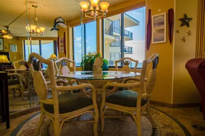 a dining room with a table and chairs at Sunbird 1008W 'Hugo's Sugar Shack' in Panama City Beach