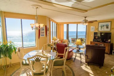a living room with a table and chairs at Sunbird 1008W 'Hugo's Sugar Shack' in Panama City Beach